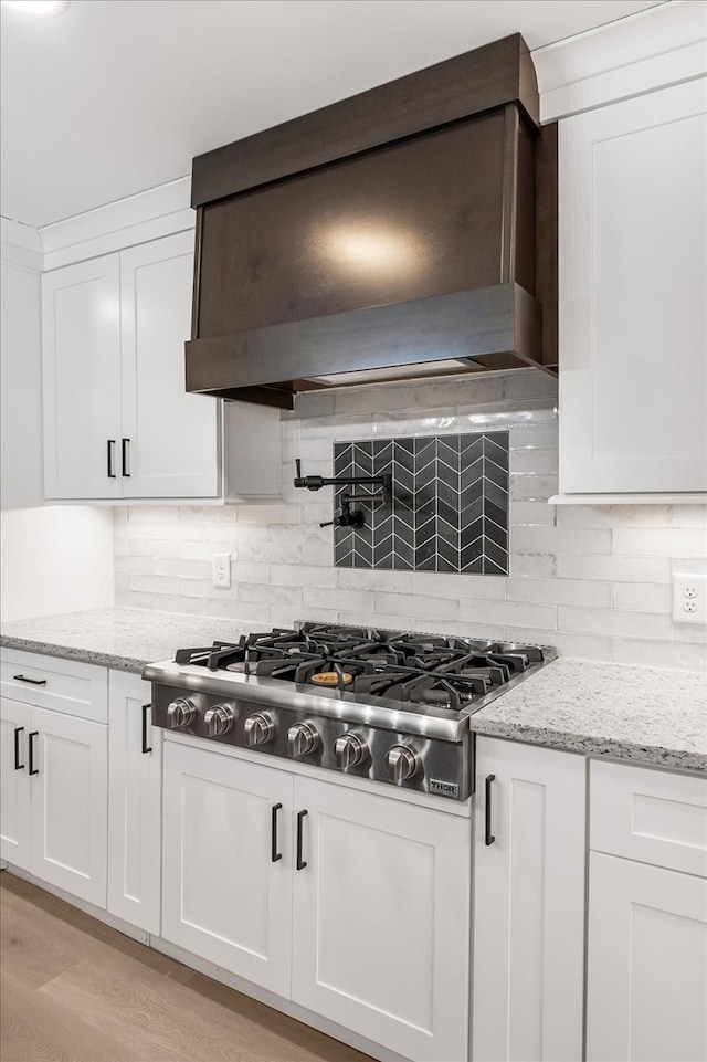 kitchen with white cabinets, light hardwood / wood-style floors, and stainless steel gas cooktop