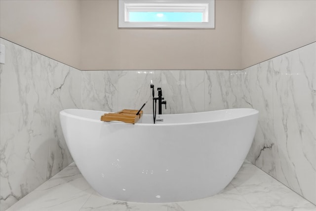 bathroom with a washtub and tile walls