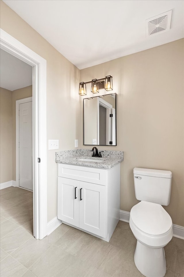 bathroom with tile patterned flooring, vanity, and toilet