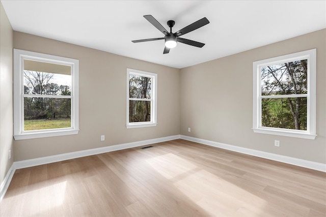 unfurnished room with ceiling fan, plenty of natural light, and light wood-type flooring