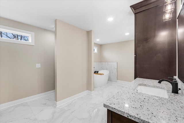 bathroom with a tub and vanity