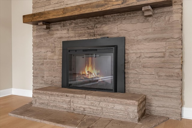 interior details with a stone fireplace and wood-type flooring