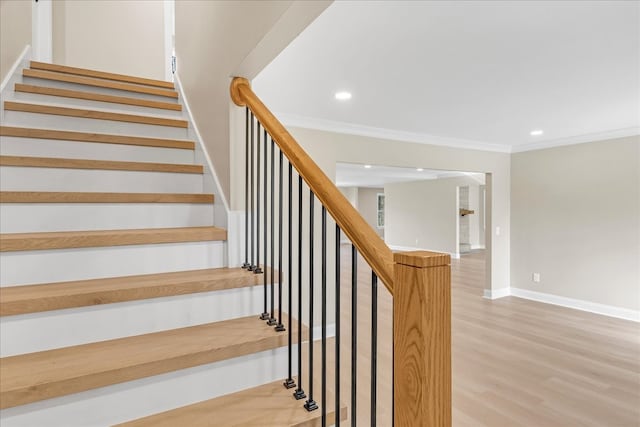 stairway with hardwood / wood-style floors and ornamental molding