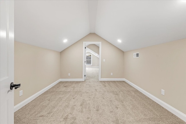 interior space with light colored carpet and lofted ceiling