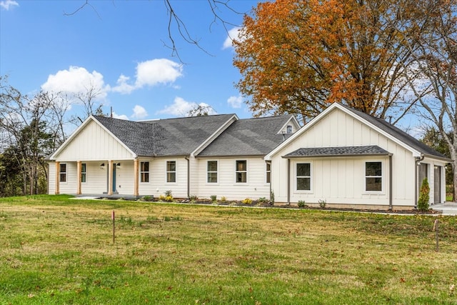 view of front of house with a front yard, a garage, and covered porch