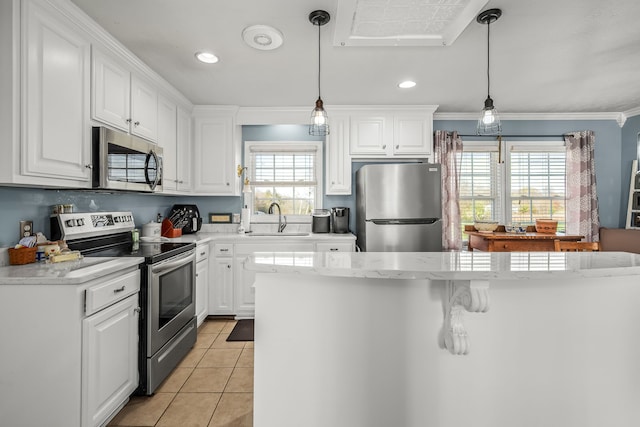 kitchen with a wealth of natural light, sink, white cabinets, and appliances with stainless steel finishes