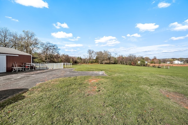 view of yard with a rural view and an outdoor structure