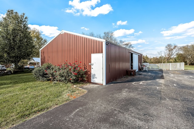 view of outdoor structure featuring a lawn and a garage