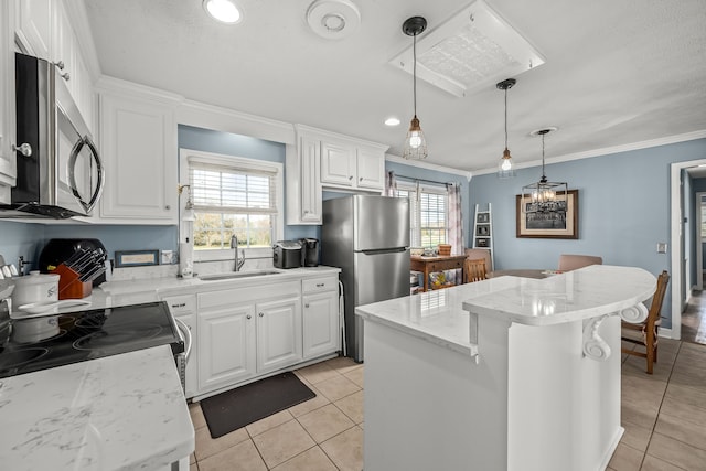 kitchen with sink, white cabinets, a kitchen island, and appliances with stainless steel finishes