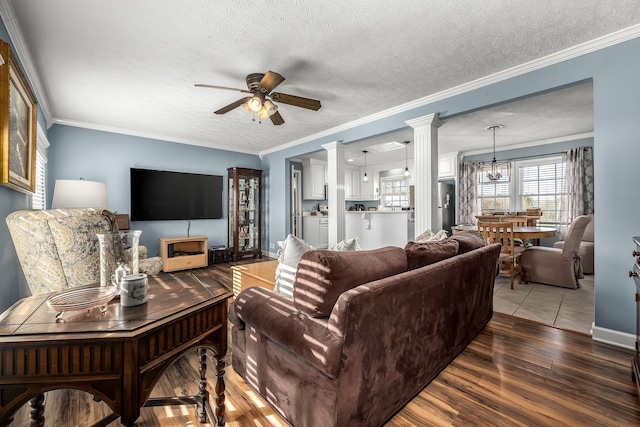 living room with hardwood / wood-style floors, ceiling fan with notable chandelier, crown molding, and a textured ceiling