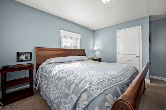 bedroom featuring a textured ceiling and dark colored carpet