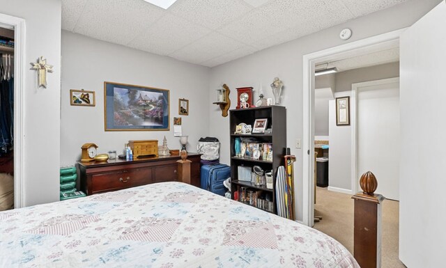 carpeted bedroom featuring a paneled ceiling