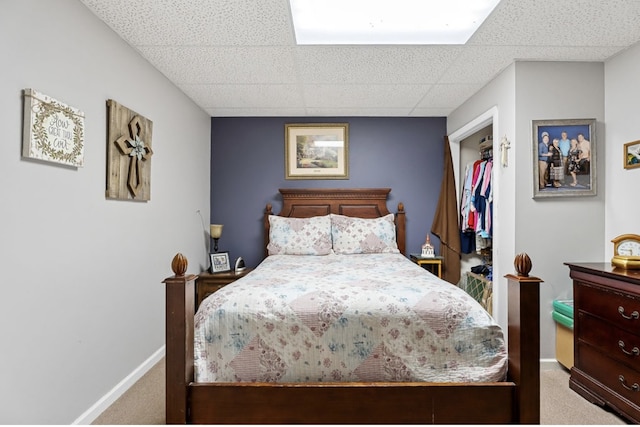 bedroom featuring carpet, a drop ceiling, and baseboards