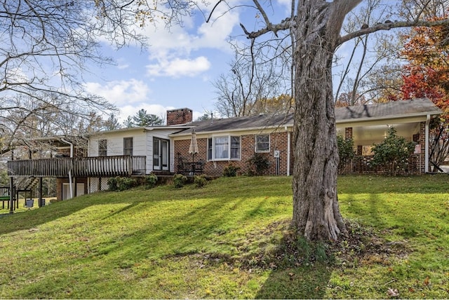 single story home with a wooden deck, a chimney, a front lawn, and brick siding