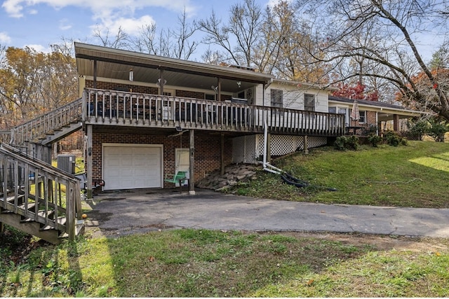 view of front of house with central AC unit, aphalt driveway, a garage, brick siding, and a front lawn