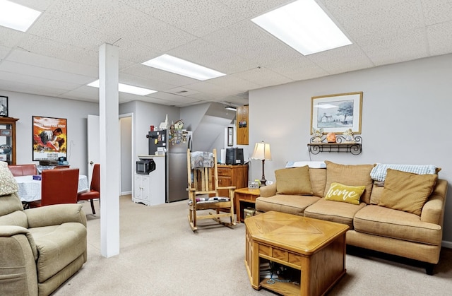 living area with light carpet and a paneled ceiling