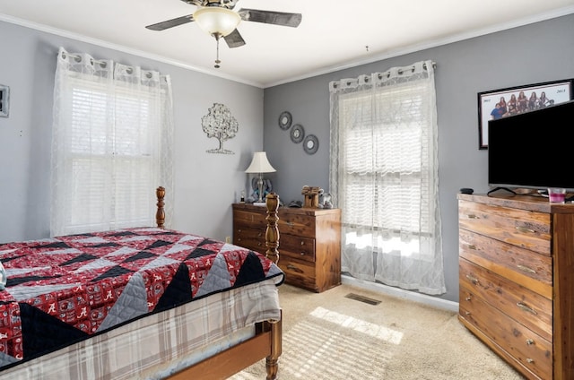 bedroom featuring a ceiling fan, carpet, visible vents, and crown molding