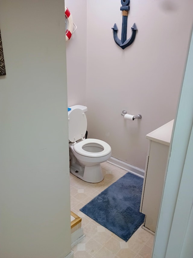 bathroom with tile patterned flooring, toilet, and baseboards