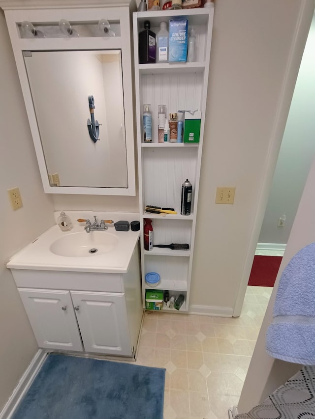 bathroom with tile patterned floors, baseboards, and vanity