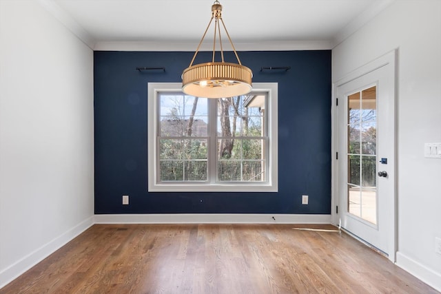 unfurnished dining area with hardwood / wood-style floors, ornamental molding, and a wealth of natural light