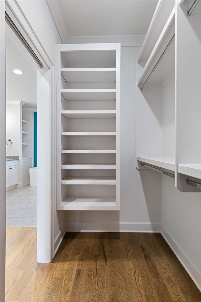 walk in closet with hardwood / wood-style flooring