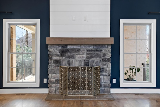 room details featuring a stone fireplace and hardwood / wood-style floors