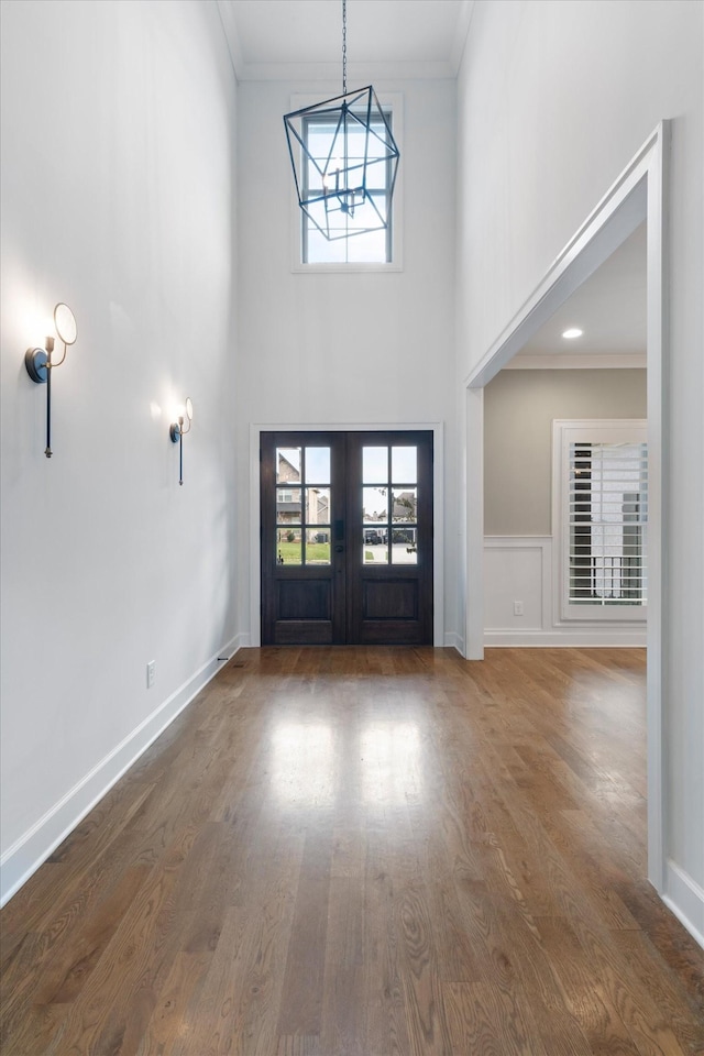 entryway featuring crown molding, dark wood-type flooring, and french doors