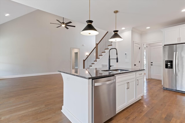 kitchen with white cabinetry, a kitchen island with sink, sink, and stainless steel appliances