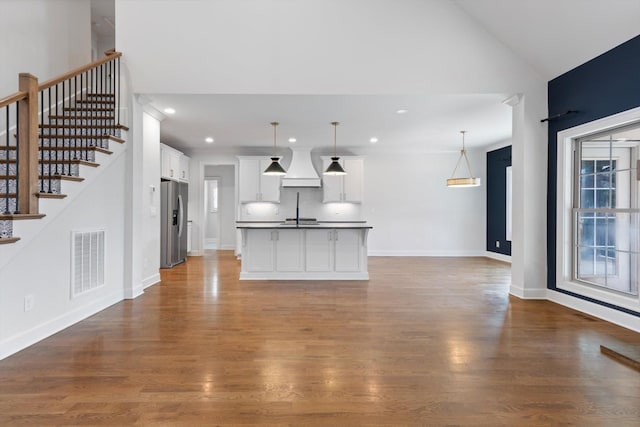 unfurnished living room with hardwood / wood-style floors and vaulted ceiling