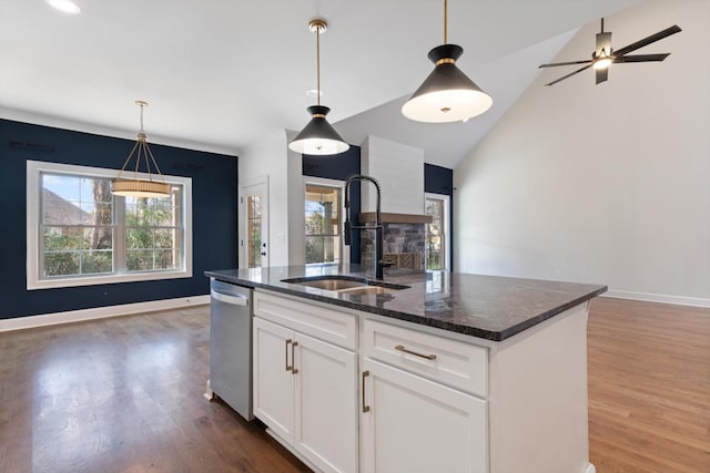 kitchen with dishwasher, white cabinets, sink, vaulted ceiling, and an island with sink