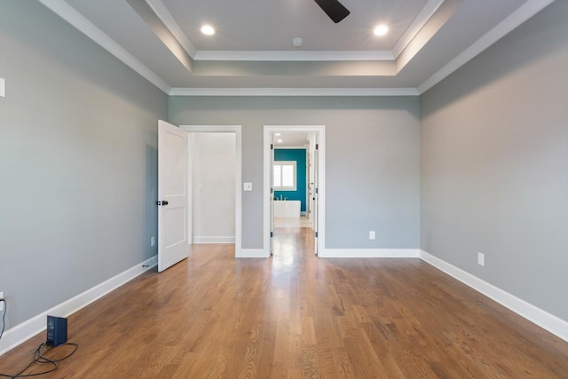 spare room featuring hardwood / wood-style flooring, a raised ceiling, ceiling fan, and ornamental molding