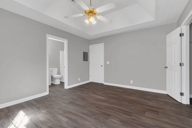 unfurnished bedroom featuring dark hardwood / wood-style flooring, ensuite bathroom, ceiling fan, and electric panel