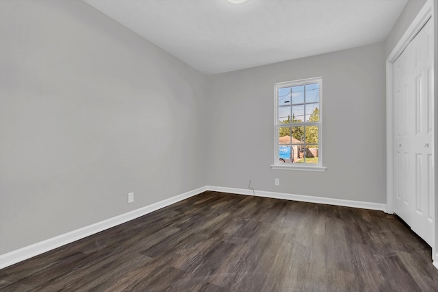 unfurnished bedroom featuring a closet and dark hardwood / wood-style floors