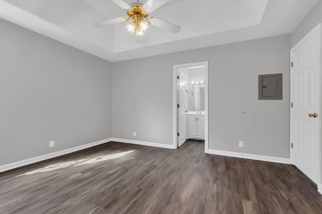 unfurnished bedroom with electric panel, ceiling fan, ensuite bathroom, and dark wood-type flooring