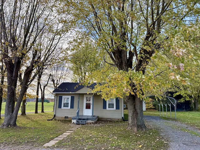 view of front of property with a carport and a front lawn