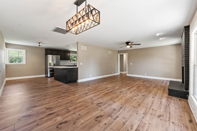 unfurnished living room featuring ceiling fan, light hardwood / wood-style flooring, and a brick fireplace