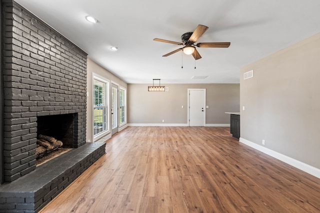 unfurnished living room featuring a fireplace, wood-type flooring, and ceiling fan