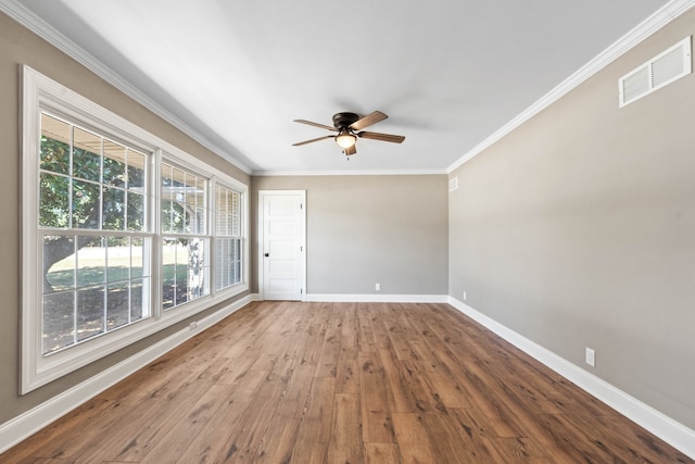 spare room featuring hardwood / wood-style flooring, a wealth of natural light, crown molding, and ceiling fan