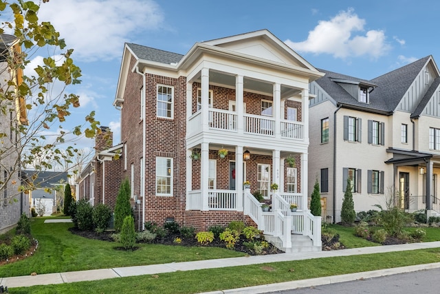 greek revival house with a porch, a balcony, and a front yard