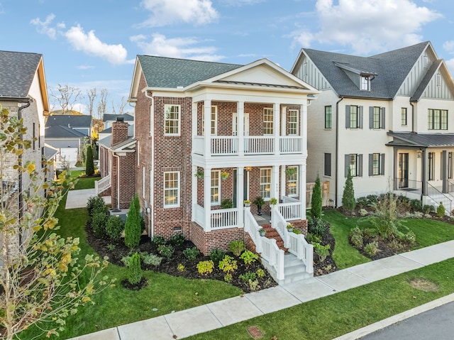 view of front of house with a balcony, a front lawn, and covered porch