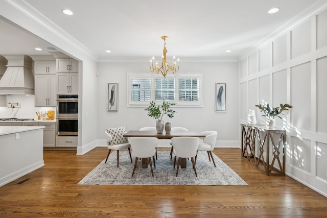 dining area featuring dark hardwood / wood-style flooring, crown molding, and a chandelier