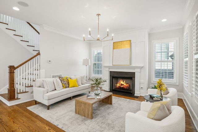 living room featuring hardwood / wood-style flooring, a notable chandelier, and ornamental molding