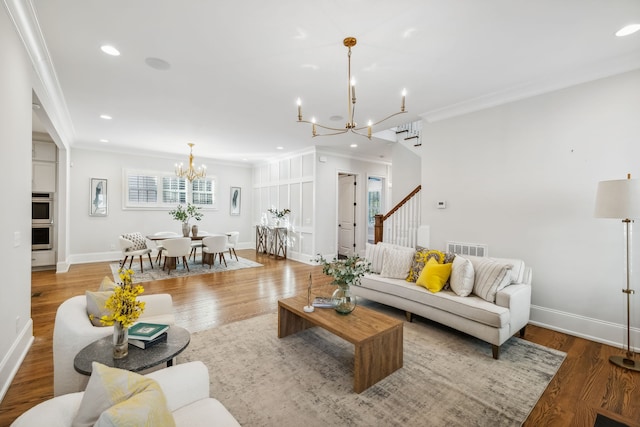 living room featuring plenty of natural light, wood-type flooring, a notable chandelier, and ornamental molding