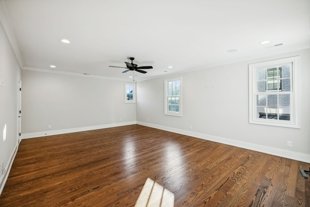 spare room featuring dark hardwood / wood-style floors, crown molding, ceiling fan, and a healthy amount of sunlight