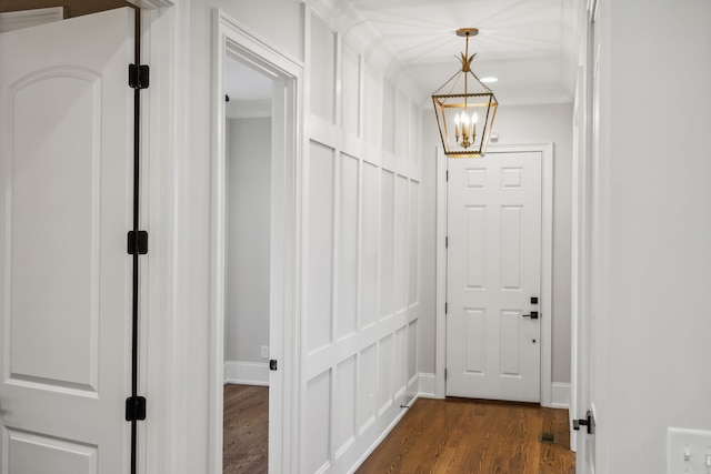 hallway featuring dark hardwood / wood-style flooring and an inviting chandelier