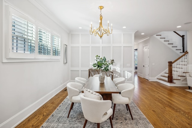 dining room with wood-type flooring, an inviting chandelier, and crown molding