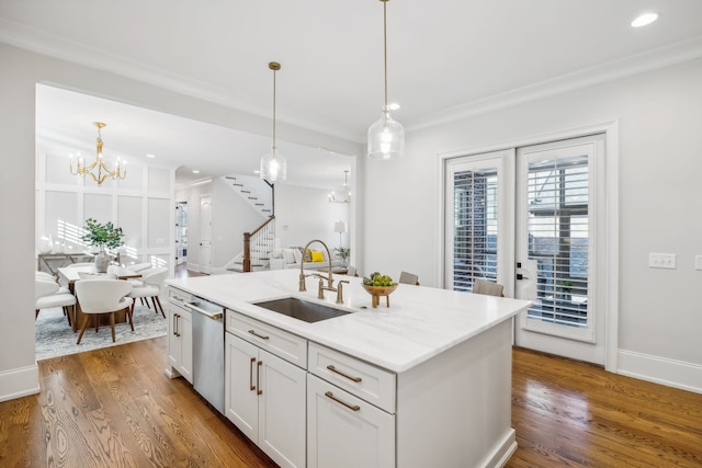 kitchen with white cabinets, stainless steel dishwasher, sink, and hardwood / wood-style flooring