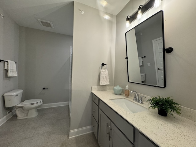 bathroom featuring tile patterned flooring, vanity, and toilet