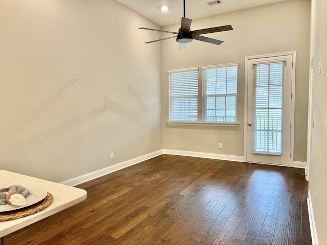 empty room featuring dark hardwood / wood-style flooring, a wealth of natural light, and ceiling fan