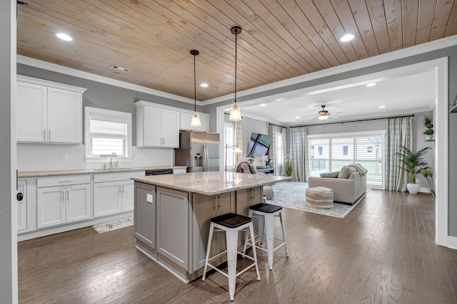 kitchen featuring a center island, stainless steel fridge, white cabinets, and wood ceiling